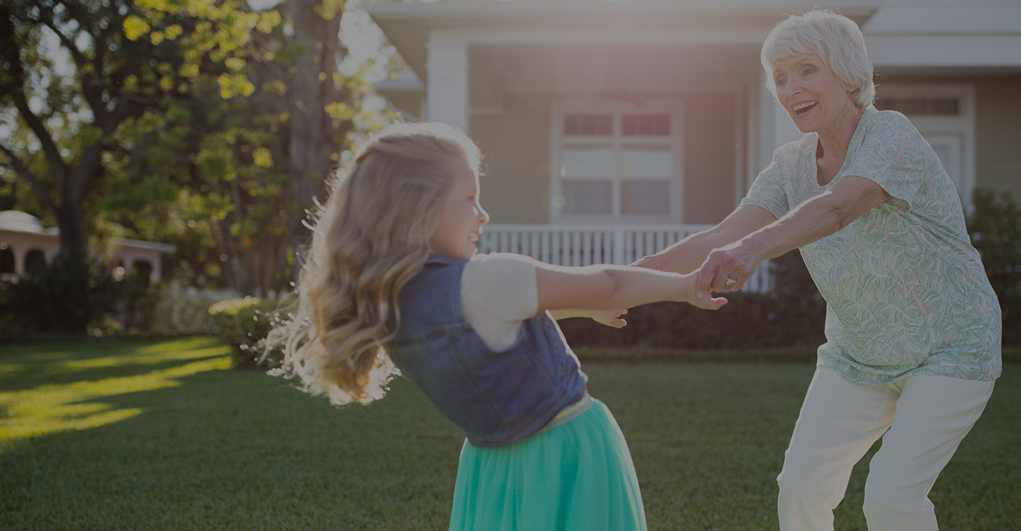 Grandmother dancing outside with grand-daughter
